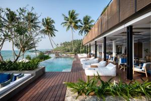 阿洪加拉Ahu Bay的一个带游泳池和椅子的度假胜地和大海