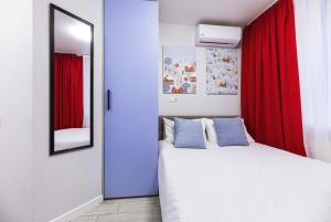 基辅MYFREEDOM Апартаменти метро Святошин的一间卧室配有一张带红色窗帘和镜子的床