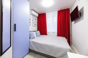 基辅MYFREEDOM Апартаменти метро Святошин的一间小卧室,配有床和红色窗帘