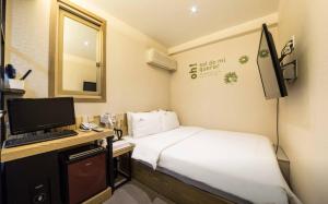 首尔Hotel Daisy的小房间设有一张床和一张带电脑的书桌