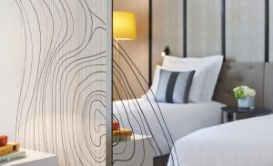 皮托巴黎拉德芳斯万丽酒店的一间卧室配有一张床和一张带台灯的桌子