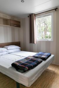 罗列特海岸Camping Tucan - Mobile Homes by Lifestyle Holidays的一间卧室配有一张床铺,床上有毯子