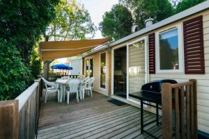 罗列特海岸Camping Tucan - Mobile Homes by Lifestyle Holidays的一个带桌椅和遮阳伞的甲板