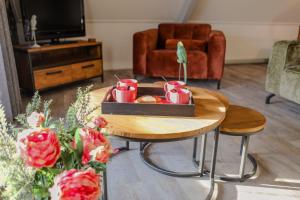 WolphaartsdijkRuim en landelijk appartement的客厅配有咖啡桌、杯子和鲜花