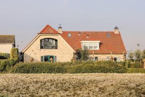 WolphaartsdijkRuim en landelijk appartement的一座红色屋顶的大房子