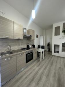 斯特雷萨Fior&Iris Apartments的厨房铺有木地板,配有不锈钢用具