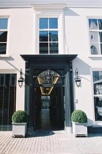 布雷达布利斯精品酒店的黑色门的白色建筑的入口