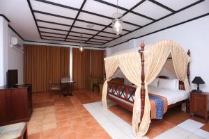 科伦坡东方大酒店的一间卧室配有一张带天蓬的床