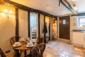 温什科姆Stunning 2 Bed Cotswold Cottage Winchcombe的厨房以及带桌椅的用餐室。