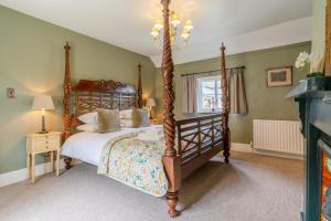 温什科姆Stunning 2 Bed Cotswold Cottage Winchcombe的一间卧室设有四柱床和一个壁炉