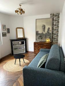 蒙雷里studio le 17 près de Paris的客厅配有蓝色的沙发和桌子