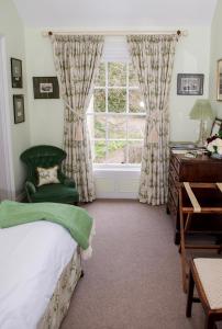 唐帕特里克Ballymote Country House的一间卧室配有一张床、一张书桌和一个窗户。