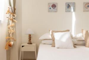 卡利亚里Follow the Sun的一间卧室配有带白色床单和枕头的床。