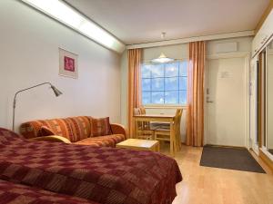 塔库沃里Hotel Tahko的酒店客房配有床、沙发和桌子。