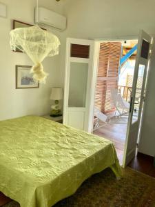 Grande AnseChambre chez l'habitant à L' Amirade chez Michelle的一间卧室配有一张带绿床罩的床