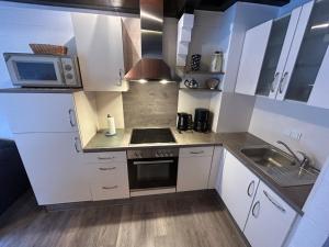 诺德代希Holiday Home Müter by Interhome的厨房配有白色橱柜、水槽和微波炉