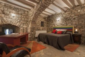 FonolleresCastell de Fonolleres的一间卧室配有一张床铺和一张位于石墙内的书桌