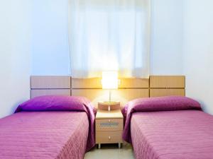 奥罗佩萨德尔马Apartment Altamar by Interhome的配有紫色床罩和灯的客房内的两张床