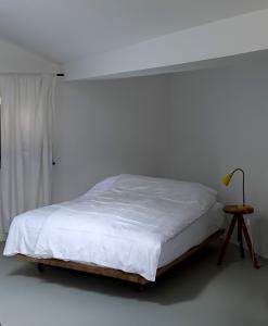 蒂罗尔州霍尔Bretzenstudios的白色卧室配有床和桌子