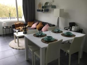 马尔梅迪Les terrasses de Malmedy duplex 420的客厅配有白色的桌子和椅子