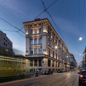 米兰Radisson Collection Hotel, Palazzo Touring Club Milan的城市街道上一座高大的汽车建筑