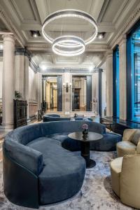 米兰Radisson Collection Hotel, Palazzo Touring Club Milan的大堂设有蓝色的大沙发和桌子
