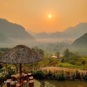 Làng CacDu Gia Panorama的日出时有稻草伞和山峰为背景