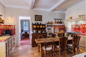 萨路特德沃克吕兹l'ermitage的厨房配有木桌和椅子