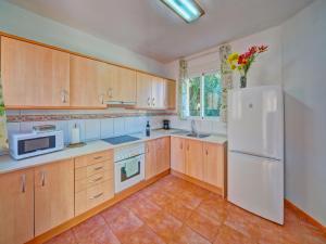 卡尔佩Apartment Canuta Baja 7 by Interhome的厨房配有木制橱柜和白色冰箱。