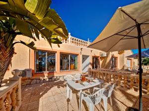 卡尔佩Apartment Canuta Baja 3 by Interhome的庭院配有桌椅和遮阳伞。