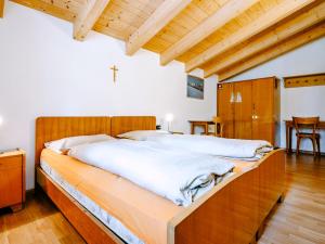 索拉加Apartment Pederiva - SOF743 by Interhome的一间卧室配有一张大床和木制床头板