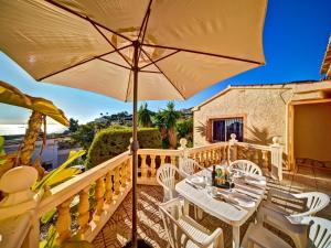 拉坎努塔Apartment Canuta Baja 2 by Interhome的庭院配有桌椅和遮阳伞。