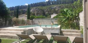 巴邦塔纳Les Cigales的一个带椅子的庭院和一个游泳池