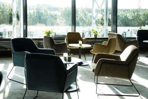 加勒穆恩Park Inn by Radisson Oslo Airport Hotel West的一间设有桌椅和窗户的等候室