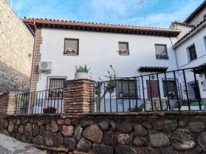 托莱多Casa Alfonso Toledo Más que una casa un hogar的白色的房子,有栅栏和石墙
