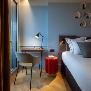 米兰Urban Hive Milano的酒店客房配有一张床、一张桌子和一把椅子。