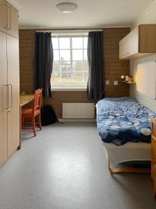 StraumenSund sommerhotell, Inderøy的一间卧室配有一张床、一张桌子和一张桌子