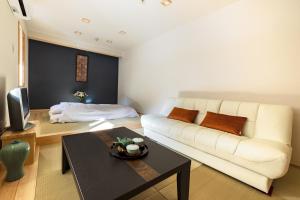 身延宿坊 志摩房 - Temple Hotel Simanobo的客厅配有白色的沙发和桌子
