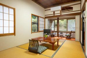 身延宿坊 志摩房 - Temple Hotel Simanobo的客厅配有木桌和椅子