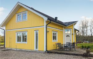 龙讷比Awesome Home In Ronneby With Kitchen的黄色房子前面有桌子