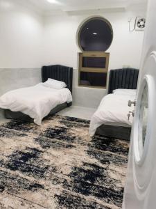 Al Hulaylahشقة مفروشه ومريحة وقريبه من المناطق السياحية عوائل فقط的一间带两张床和洗衣机的房间