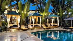 雅科欧神诺精品酒店的毗邻度假酒店的带椅子和遮阳伞的游泳池