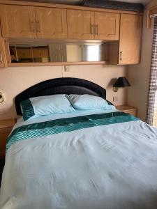 牛顿斯图尔特Immaculate 2-Bed Static Caravan at Monrieth的卧室配有一张大床和木制橱柜