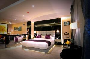 麦纳麦Frsan Palace Hotel的一间卧室配有一张带紫色枕头的大床