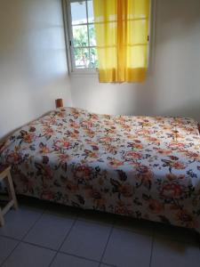 珀蒂堡Kaz A Ti Jo的一间卧室配有一张带花卉床罩的床