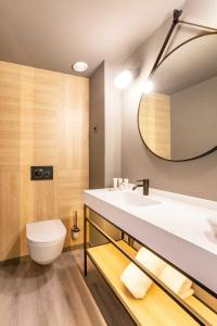 巴塞罗那巴塞罗那博览会酒店的一间带水槽、卫生间和镜子的浴室