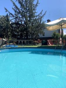 casa nonna Rica的一个带遮阳伞的大型蓝色游泳池
