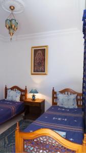 苏塞Dar El Goulli的一间卧室配有两张床和一张带台灯的桌子