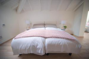 科莫客莫凡公寓度假屋的白色卧室配有一张带粉色毯子的床