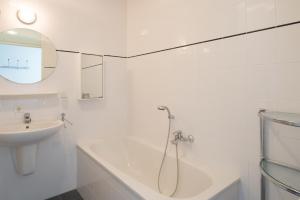 布雷斯肯斯Hello Zeeland - Appartement Port Scaldis 19-042的带淋浴和盥洗盆的白色浴室
